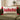 rectangle cushion: lifestyle view 2 of the rectangular bouclé cushion with ho ho ho embroidery and tassels styled in a festive home setting