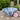 Decorative blue floral patterned bowl on a table with pink flowers and petals, outdoor setting.