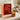 Orange home fragrance set and its packaging on polished white kitchen countertop.