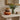 Three stacked velvet decorative autumn cushions shaped like pumpkins in orange, brown, and tan tones