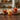 Set of three decorative floral candles on dark brown wooden kitchen countertop.