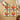 Set of 4 tomato coasters on wooden countertop with a bowl of tomatoes, a tea towel and a glass of water.
