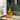 Orange diffuser bottle with reeds on a table in a room setting