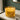 Two lit candles in a glass container on a marble surface with a blurred background