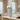 Decorative vase with white flowers on a table next to a mirror