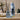 A blue glass large reed diffuser bottle with black reeds stands on a tabletop beside its packaging