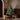Small Christmas tree with wooden feet displayed beside wrapped Christmas presents