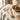 Wooden utensils with tomato-painted handles on table next to bowl of tomatoes.
