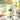 White ceramic pitcher with strawberry design on a table with glasses and plants.