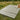 Striped picnic mat on grass with a basket and food items