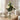 Bouquet of white roses in a glass vase on a wooden table with books and a diffuser.