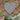 Wicker heart wall decoration on brick wall with plants